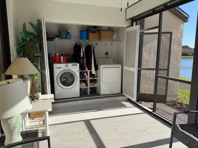 laundry area with washer and clothes dryer, laundry area, and marble finish floor