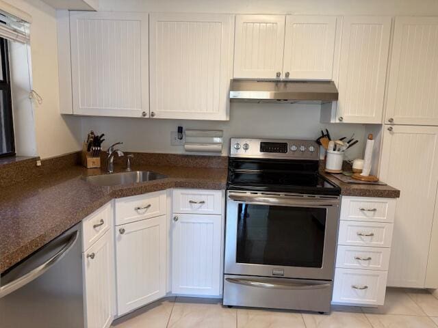 kitchen featuring under cabinet range hood, white cabinetry, stainless steel appliances, and a sink