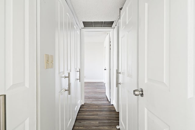 hallway featuring dark hardwood / wood-style flooring and a textured ceiling