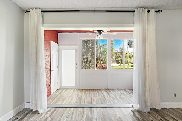 spare room with ceiling fan, hardwood / wood-style flooring, and a textured ceiling