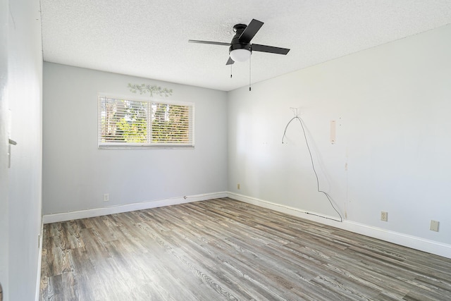 empty room featuring wood-type flooring, ceiling fan, and a textured ceiling