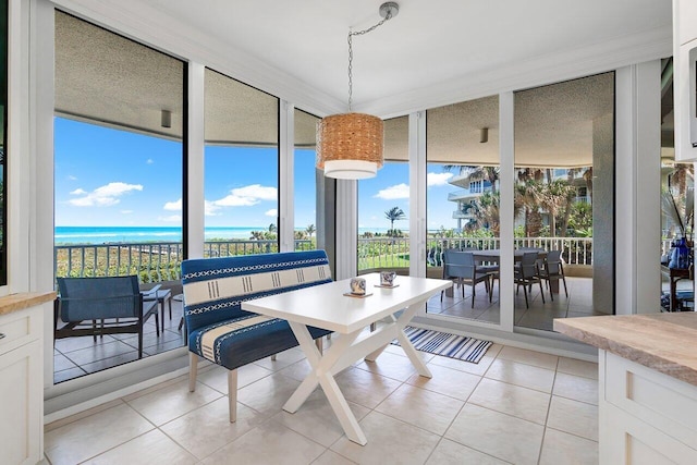 tiled dining space with a wealth of natural light and a water view