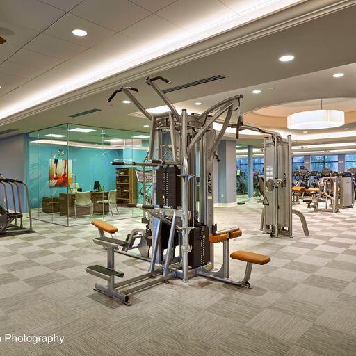 workout area featuring a raised ceiling, carpet, and ornamental molding