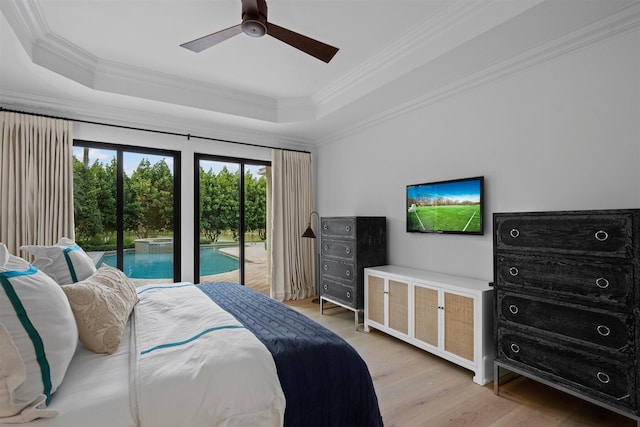 bedroom featuring ornamental molding, light wood-type flooring, ceiling fan, and a raised ceiling