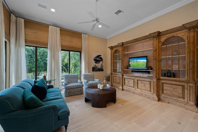 living room featuring ornamental molding, light hardwood / wood-style floors, and ceiling fan