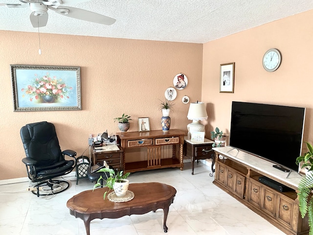 sitting room with light tile floors, ceiling fan, and a textured ceiling