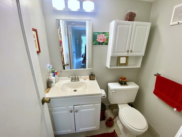 bathroom featuring tile floors, large vanity, and toilet