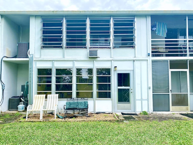 rear view of property featuring a yard and a balcony