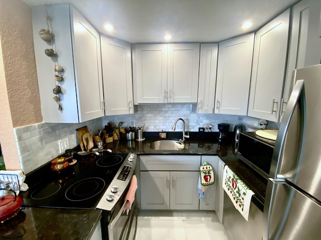 kitchen featuring backsplash, appliances with stainless steel finishes, light tile floors, and sink