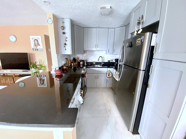 kitchen with gray cabinetry, tasteful backsplash, stainless steel refrigerator, and light tile floors