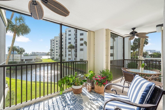 balcony with a water view and ceiling fan