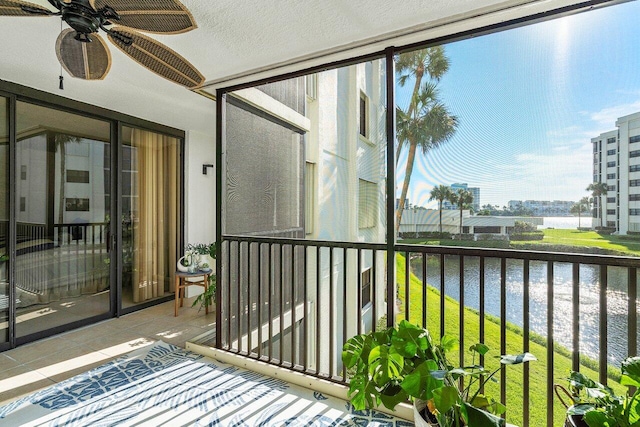 balcony with a water view and ceiling fan