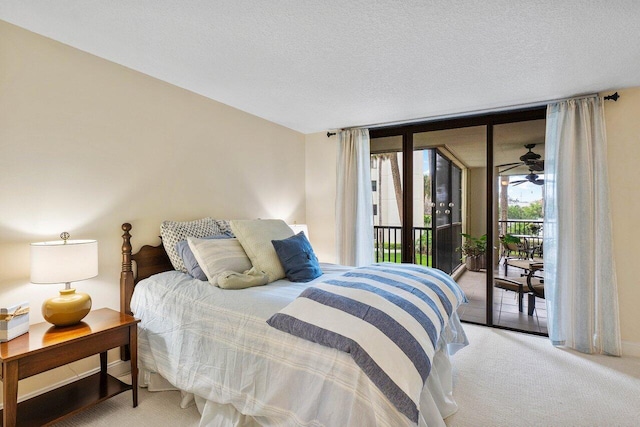 bedroom featuring light carpet, a textured ceiling, a wall of windows, and access to exterior