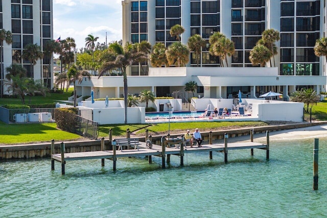 view of dock with a yard and a water view