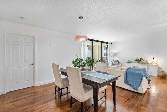 dining space with a textured ceiling and dark hardwood / wood-style floors