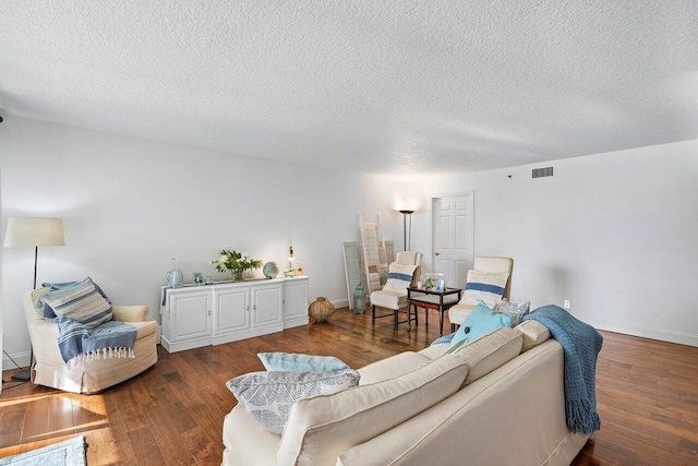 living room with dark wood-type flooring and a textured ceiling