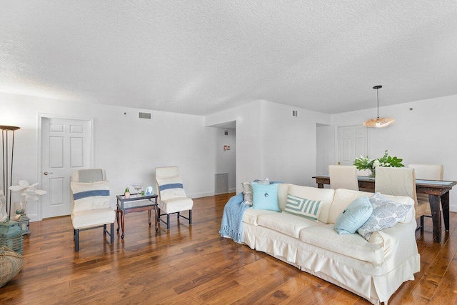 living room featuring a textured ceiling and wood-type flooring