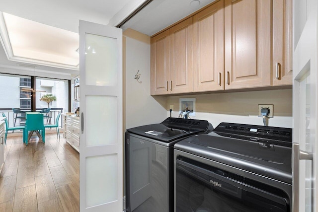 clothes washing area with light hardwood / wood-style flooring, cabinets, and independent washer and dryer