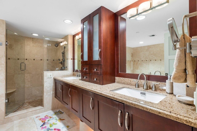 bathroom with tile patterned floors, double sink vanity, and a shower with door