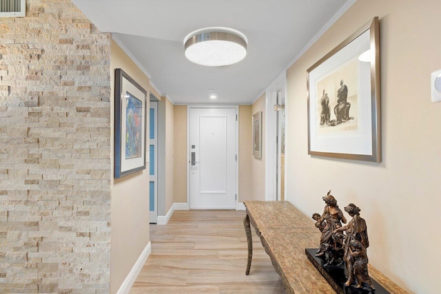 doorway to outside with light wood-type flooring and ornamental molding