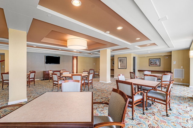 dining area with a raised ceiling and carpet flooring