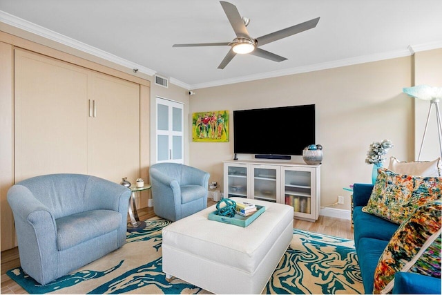 living room featuring ceiling fan, light hardwood / wood-style flooring, and crown molding