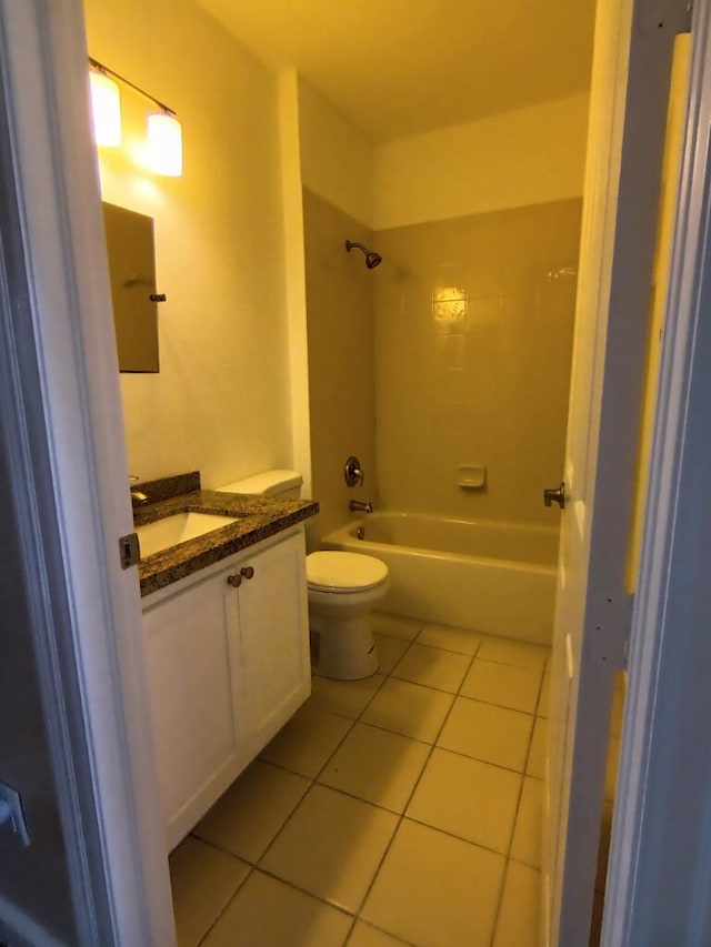 full bathroom with toilet, vanity with extensive cabinet space, tile floors, and tiled shower / bath combo