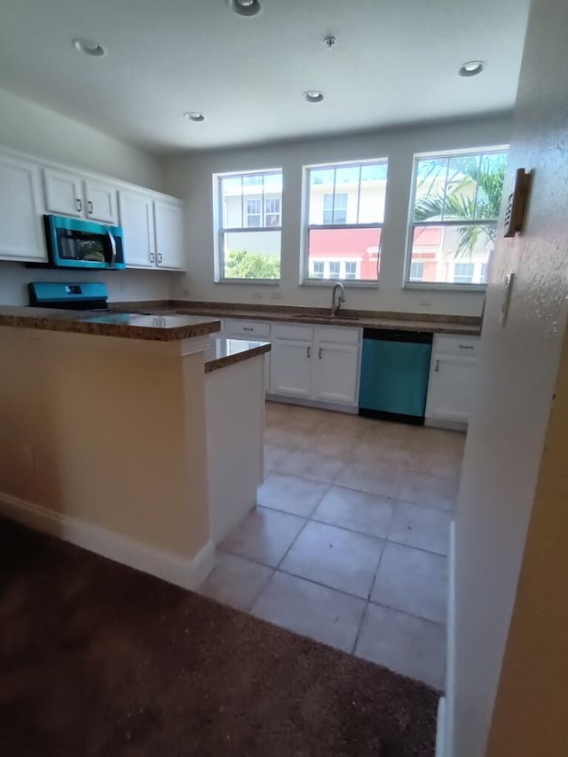 kitchen featuring light tile floors, appliances with stainless steel finishes, white cabinetry, and sink