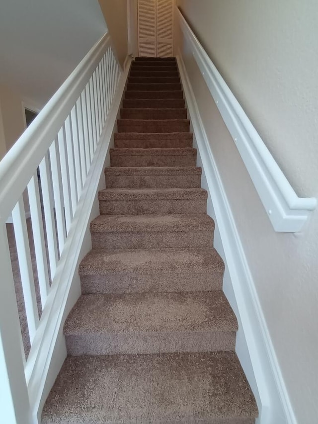 stairs featuring carpet flooring