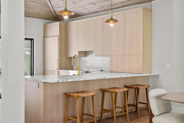 kitchen with decorative light fixtures, light brown cabinetry, light stone counters, wooden ceiling, and light hardwood / wood-style floors