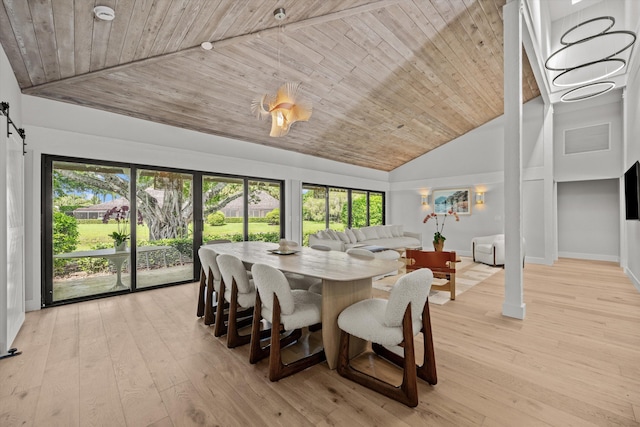 dining room featuring wood ceiling, high vaulted ceiling, light hardwood / wood-style flooring, and a barn door