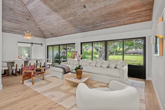 living room with wood ceiling, high vaulted ceiling, a barn door, and light hardwood / wood-style floors