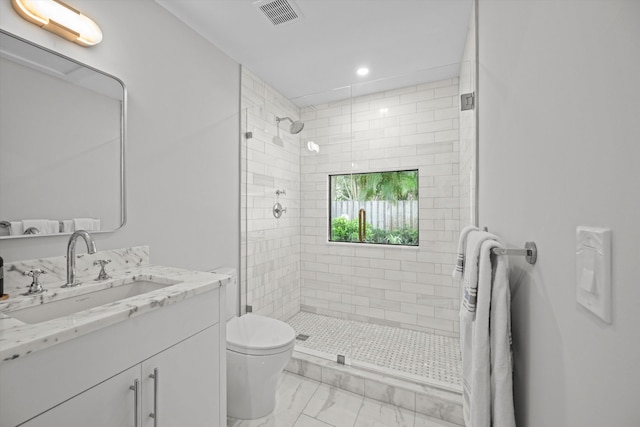 bathroom with toilet, a shower with door, and vanity