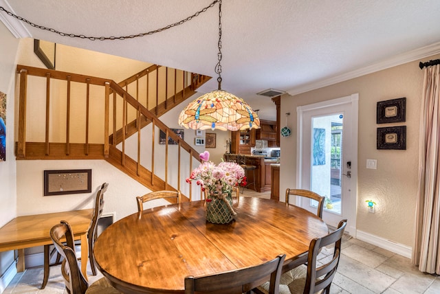 dining space featuring a textured ceiling and ornamental molding