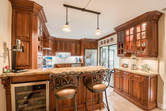 kitchen featuring light stone counters, wine cooler, appliances with stainless steel finishes, and kitchen peninsula