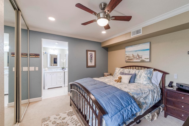 bedroom with crown molding, light colored carpet, ceiling fan, and ensuite bathroom