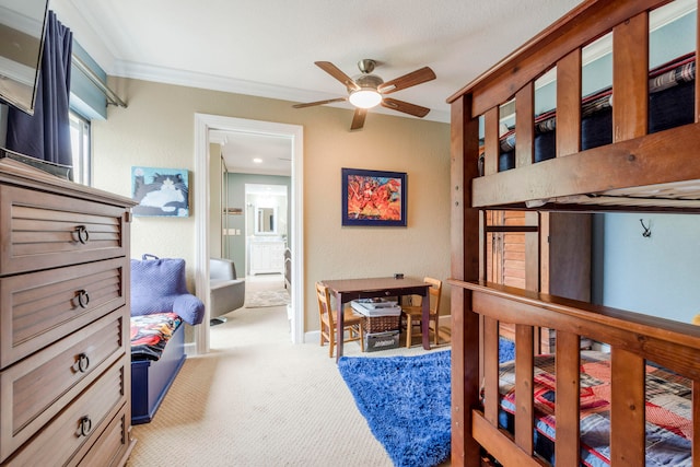 carpeted bedroom featuring ceiling fan and crown molding