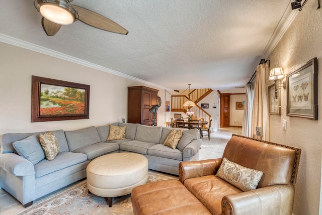 living room with ceiling fan, a textured ceiling, and ornamental molding