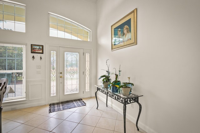 tiled entrance foyer featuring a towering ceiling