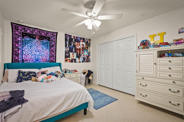 tiled bedroom with a textured ceiling, a closet, and ceiling fan