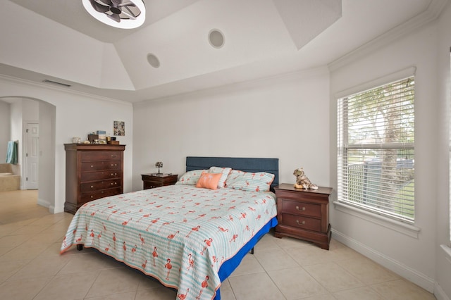 bedroom featuring ornamental molding, light tile patterned floors, and a tray ceiling