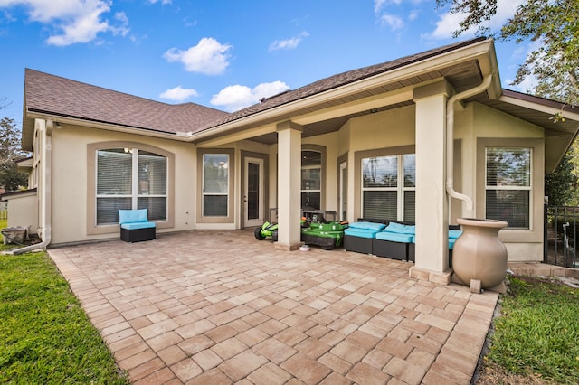 rear view of house featuring an outdoor living space and a patio area