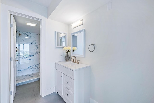 bathroom with oversized vanity, a tile shower, and tile floors