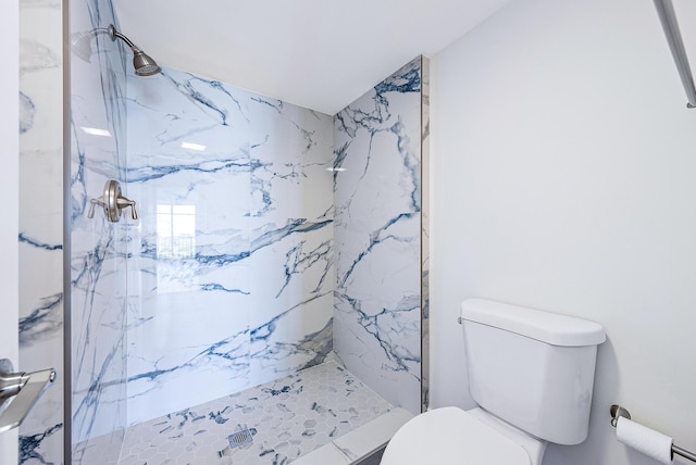 bathroom with toilet and a tile shower