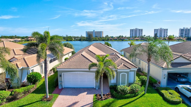 exterior space with a front lawn, a garage, and a water view