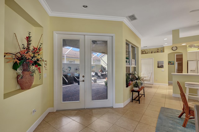 entryway with light tile floors, french doors, and ornamental molding