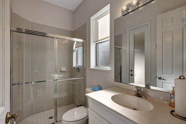 bathroom with toilet, a shower with shower door, and vanity