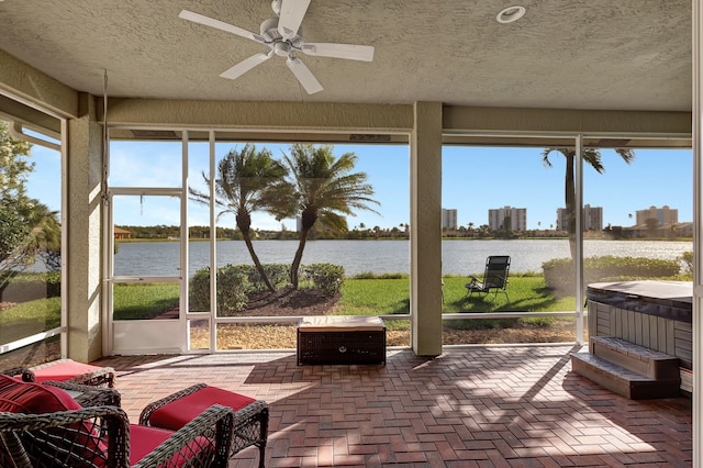 sunroom / solarium featuring a water view, a healthy amount of sunlight, and ceiling fan