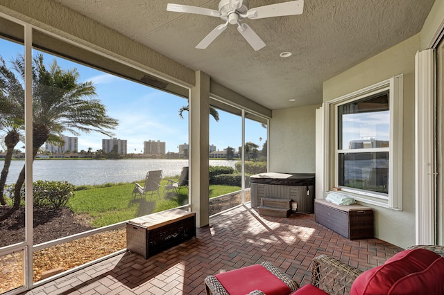 sunroom / solarium featuring a water view and ceiling fan