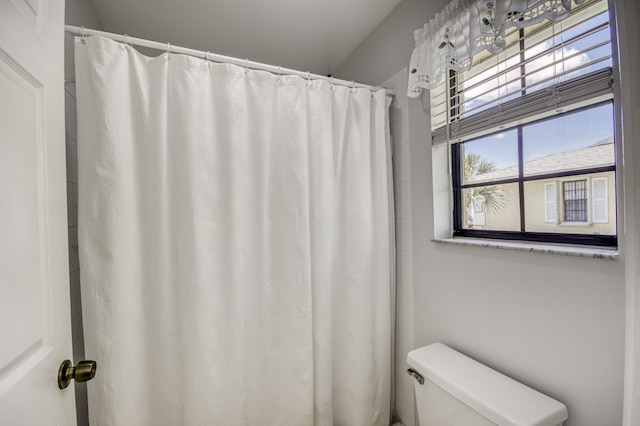 full bath featuring toilet and a shower with shower curtain